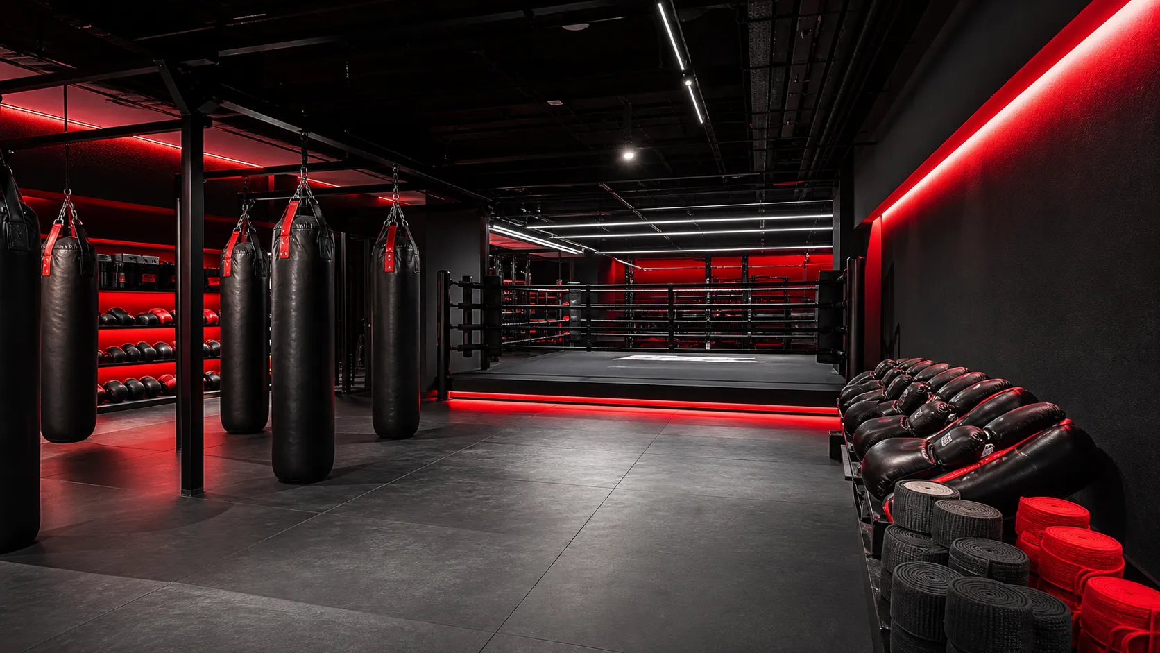 Gimnasio premium de kick boxing con bolsas, ring y luces rojas